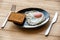 Fried egg close up in a black plate on a wooden table - Sunny side soft fried egg