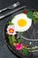 Fried egg with a decor of microgreens, food flowers, sorrel and nasturtium