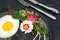 Fried egg with a decor of microgreens, food flowers, sorrel and nasturtium