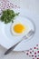 Fried egg in a heart shape with Rocket in a white plate