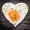 Fried egg with heart shape on wooden table, concept love
