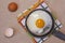 Fried egg on the pan, egg shells, dish towel.
