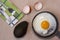 Fried egg on the pan, fork and knife, avocado, egg shell, dish towel.