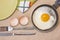 Fried egg on the pan, fork and knife, green plate, egg shell, dish towel.