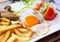 Fried egg with potato fries, grilled steak.