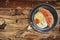 Fried Egg And Prosciutto Rashers In Teflon Frying Pan Set On Old Cracked Flaky Wooden Garden Table
