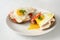 Fried egg with running yolk on wholemeal bread rolls with tomato, cucumber and cooked ham, healthy hearty breakfast on a white