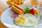 Fried egg with sausage and ham served with vegetable salad for appetizing breakfast