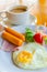 Fried egg with sausage and ham served with vegetable salad and hot coffee for appetizing breakfast