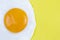 Fried egg sunny side up close up on yellow background with copy space