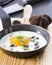 Fried egg with truffle in a pan on a cutting board.