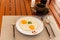 Fried egg on a white plate with coffee cup in morning breakfast.