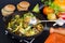 Fried eggplant, paprika and different vegetables in pan on black background