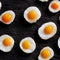 Fried eggs on black slate background in seamless food pattern