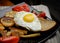 Fried eggs on bread. Plate of grilled vegetables.