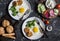 Fried eggs, chicken meatballs, vegetables, and yogurt sauce on a dark background.