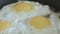 The fried eggs cooked on a pan close up slowmotion