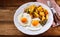 Fried eggs with crispy roast potatoes and gherkin