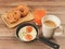 Fried eggs ,cup of coffee , danish pastry and Croissant on wooden background