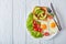 Fried eggs, fresh salad, toast on a plate