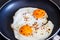 Fried eggs in a frying pan with chili peper