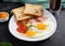 Fried eggs with ham, tomatoes and toasts. Delicious English Breakfast.