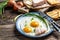 Fried eggs with lard bacon on the wooden table, Traditional Ukrainian or belorussian food, Food recipe background. Close up