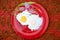 Fried eggs, omelet on a red plate