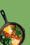 Fried eggs on a pan with tomatoes and parsley leaves. Top view