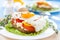 Fried eggs with peppers and tomatoes on a white plate