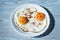 Fried eggs on a plate with chili peper