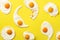 Fried eggs or scrambled eggs pattern on yellow background. Creative food concept. Top view. Minimalistic style