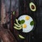 Fried eggs with spinach and pieces of avocado on wooden tabletop