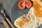 Fried eggs with tomato and thyme and spices on a gray plate close-up