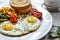Fried eggs with tomatoes, green beans, corn and toast. English vegetarian breakfast. Coffee and fried eggs close-up