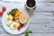 Fried eggs with tomatoes, green beans, corn and toast. English vegetarian breakfast. Coffee and fried eggs. Light wooden