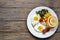 Fried eggs with tomatoes, green beans, corn and toast. English vegetarian breakfast. Top view. Wood background. Free space for