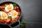 Fried eggs with vegetables: tomatoes, paprika, peppers, onions. Vegetable Shakshuka in a pan. Top view.