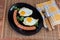 Fried eggs and wiener on dish, fork, knife on napkin