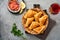 Fried empanadas with cilantro, meat, egg, tomato and chili sauce on grey background. Chilean typical dish. Latin American and