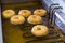 Fried equal round doughnuts in deep-fryer