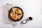 Fried eryngii mushrooms in cast-iron pan on white table. Grilled slices of king oyster mushrooms. Top view, copy space