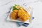 Fried Fish and Chips with lime in a dish basket isolated on napkin side view on grey background famous indian and pakistani food