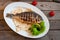 Fried fish Dorada, sea bream with spices, herbs and lemon fried on a grill on a white plate