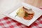 Fried fish filet with mashed potatoes and tomato sauce served on white square plate on wooden table.