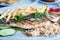 Fried fish with potatoes with vegetables on a white plate at traditional Greek tavern