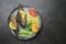 Fried fish and vegetables on a plate. Concrete gray countertop