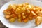 Fried golden potatoes on a white plate. Fried potato wedges