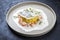 Fried haddock filet with saffron rice and shell prawns in crab sauce on a modern design plate