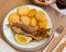 Fried hake served with boiled potatoes and lemon